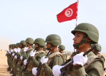 Tunisian soldiers listen to the national anthem along the frontier with Libya in Sabkeht Alyun,Tunisia February 6, 2016. Tunisia has completed a 200-km (125 mile) barrier along its frontier with Libya to try to keep out Islamist militants, and will soon install electronic monitoring systems, Defence Minister Farhat Hachani said on Saturday. REUTERS/Zoubeir Souissi